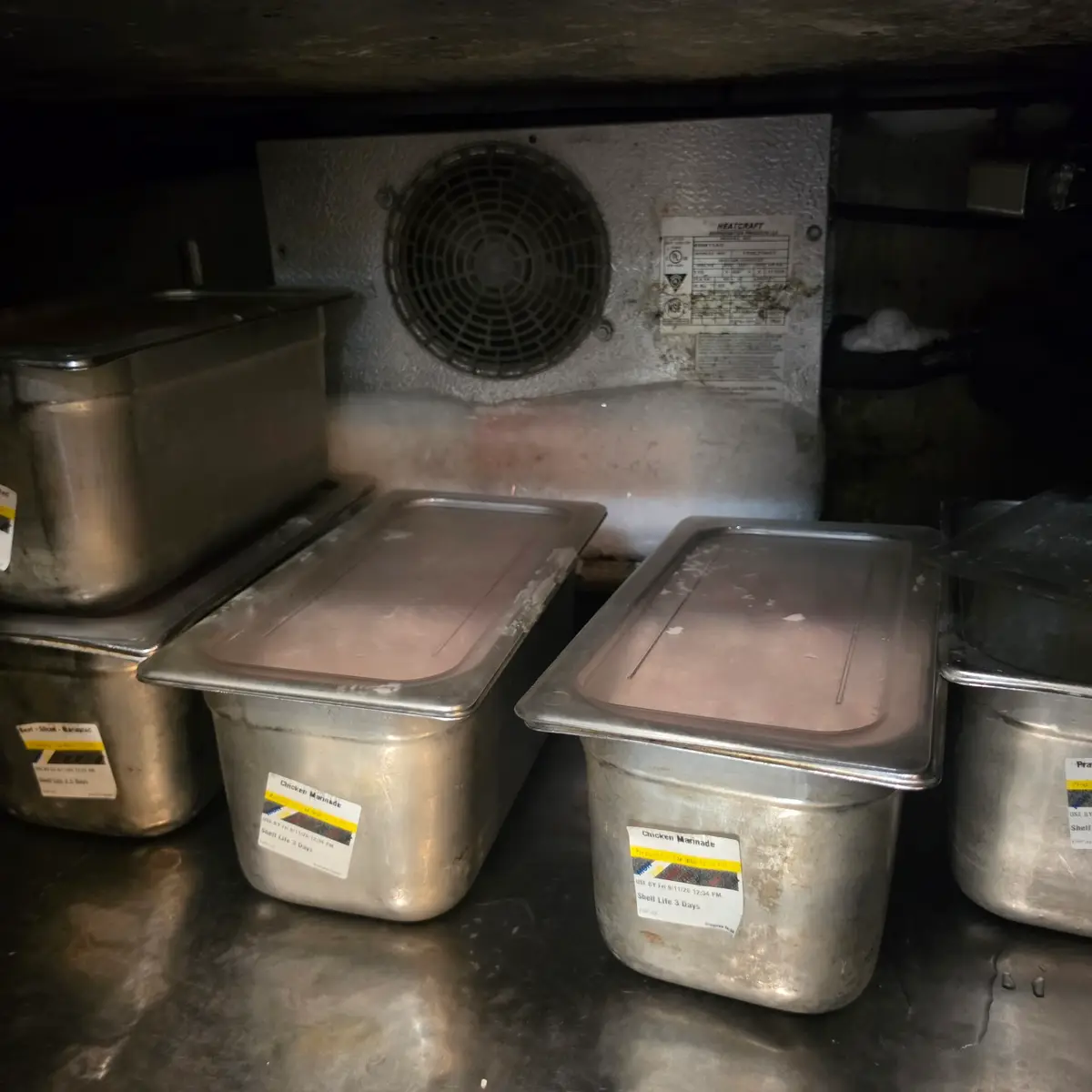 Ice accumulation around the evaporator and fan section of a commercial refrigerated prep table in Tucson