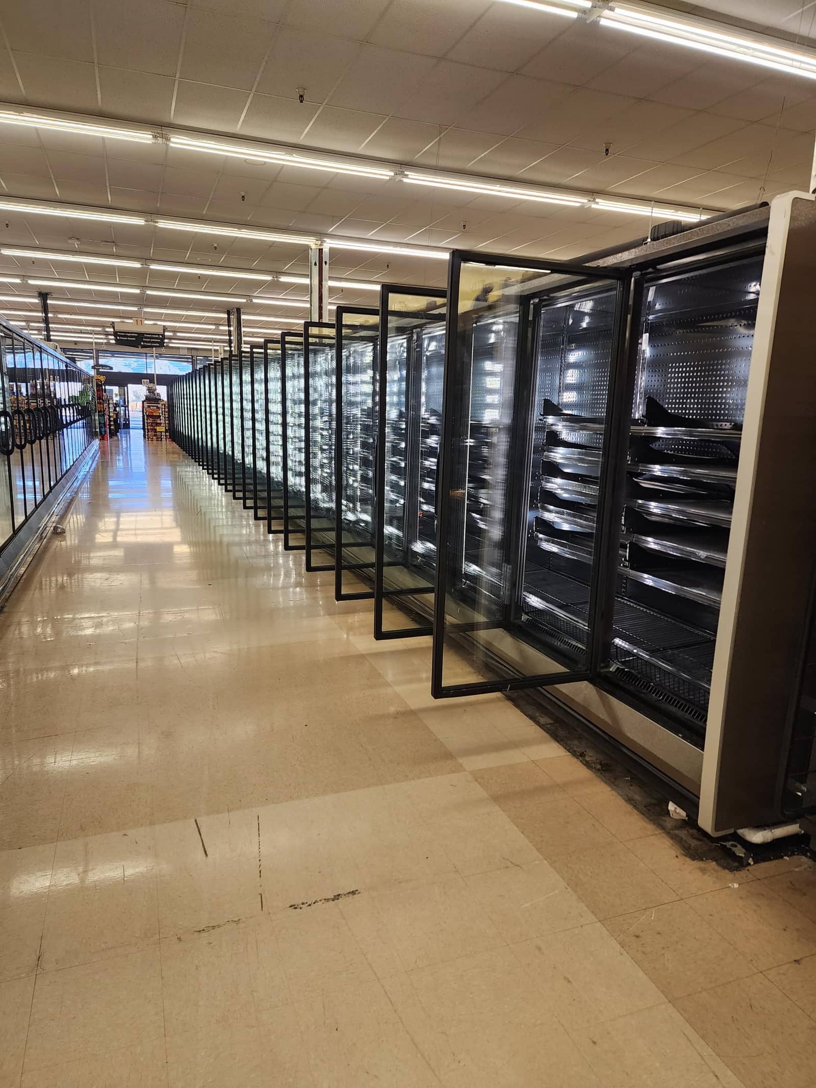 Supermarket refrigeration aisle with a long run of glass-door reach-in display cases