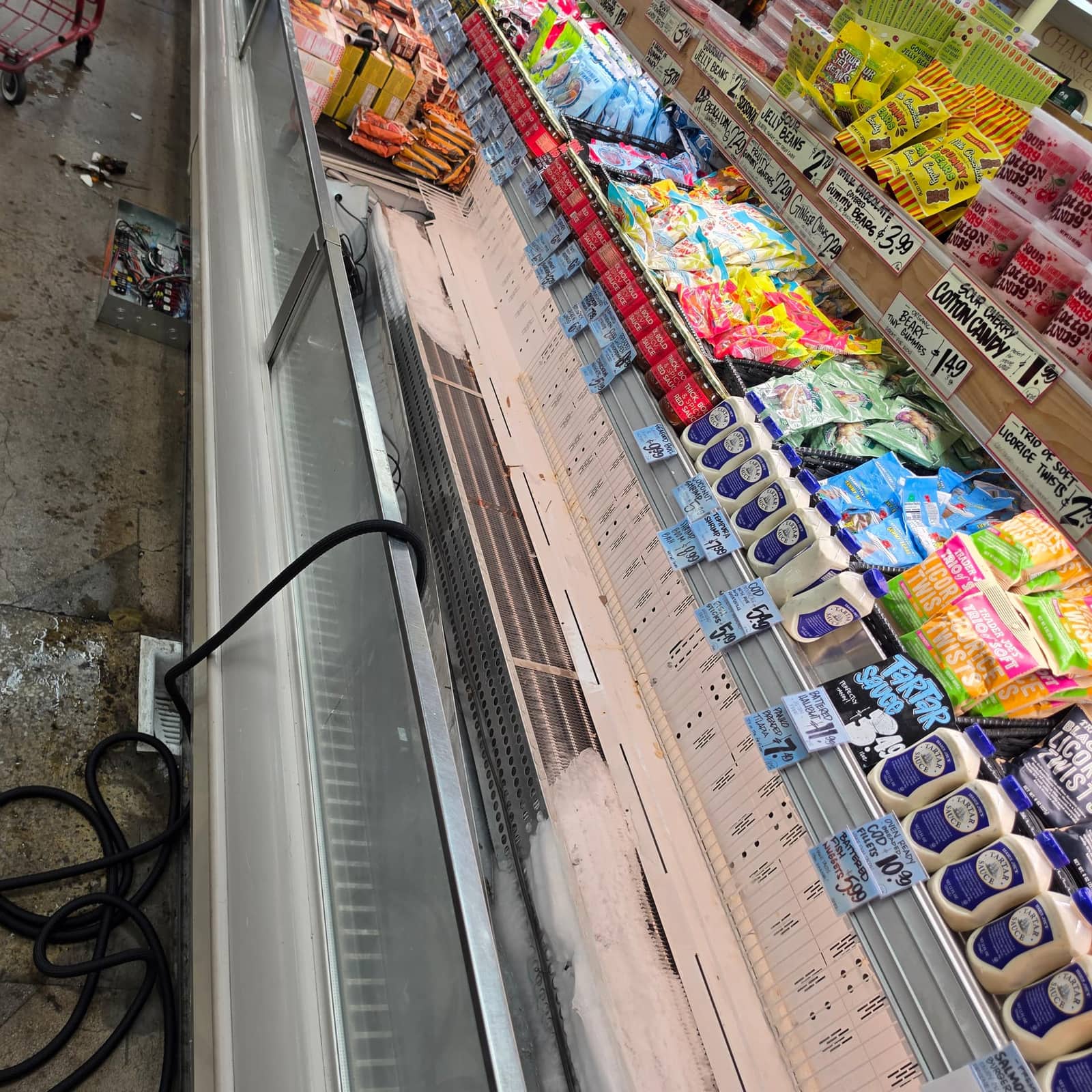 Open display case with the panel removed, exposing a frosted evaporator coil during service