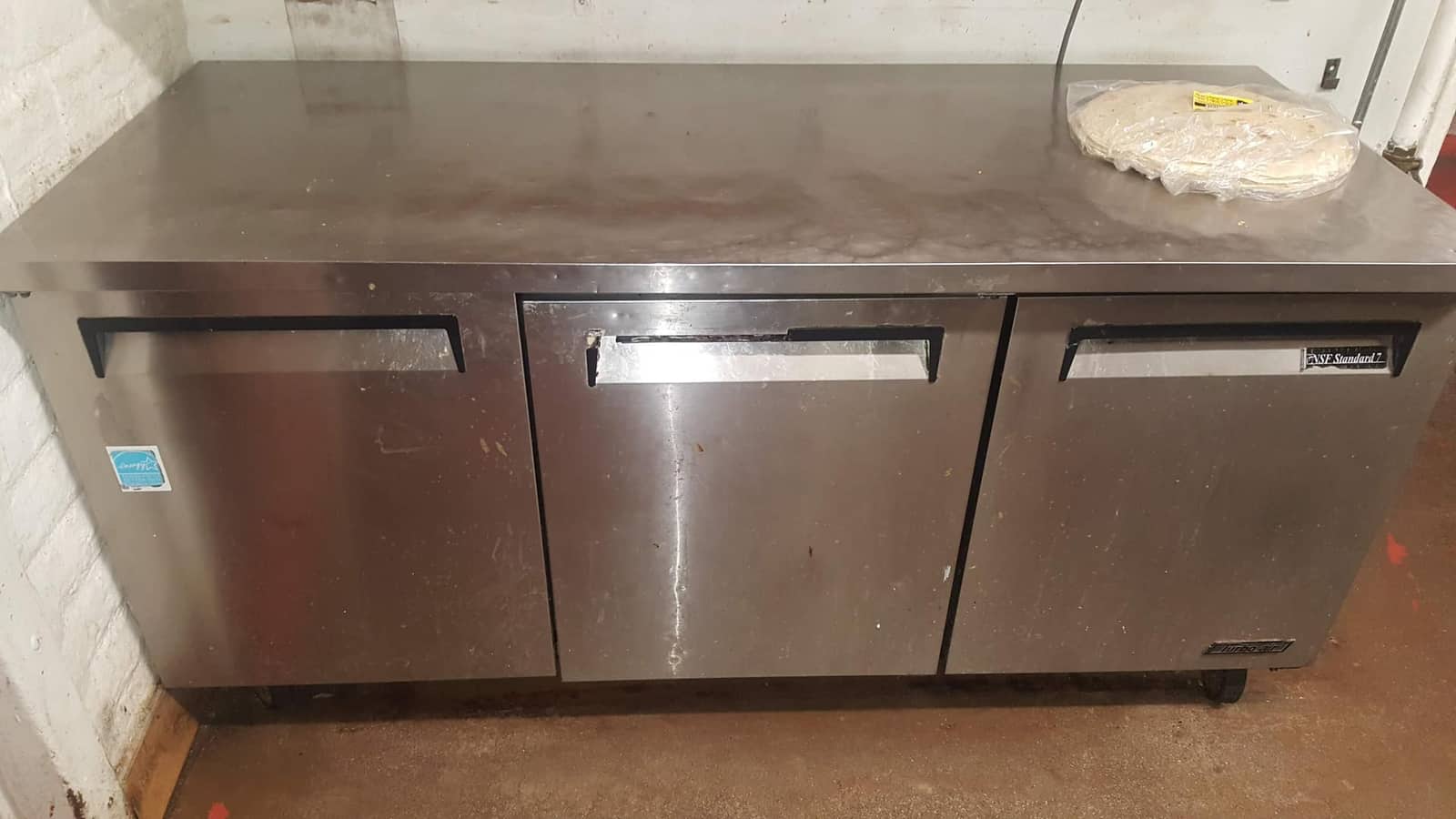 Three-door Turbo Air stainless-steel undercounter worktop refrigerator in a commercial kitchen